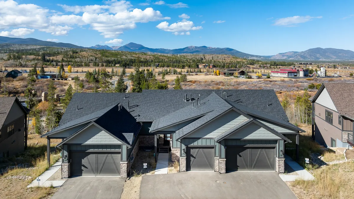 A welcoming view of the home's modern exterior architecture set against a stunning mountain backdrop. The spacious driveway and well-maintained surroundings suggest privacy and exclusivity while connecting the home to its beautiful natural setting.
